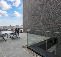 RIVERS I Prémiový 4-izbový byt s panoramatickým výhľadom na mesto - Terasa so stoličkami a stolom v 4-izbovom byte s výhľadom na Bratislavu.