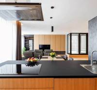 RIVERS I Prémiový 4-izbový byt s panoramatickým výhľadom na mesto - Kuchyňa v 4-izbovom byte so sklenenou stenou a jedálenským stolom s kvetmi.