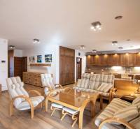 Nadštandardný 4-izbový rodinný dom s garážou a veľkým pozemkom - Interiér rodinného domu s priestrannou obývačkou, kuchynskou linkou a podlahou s dreveným dekorom.