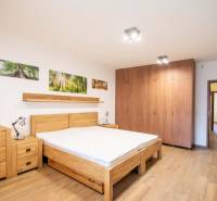 Nadštandardný 4-izbový rodinný dom s garážou a veľkým pozemkom - Spálňa v rodinnom dome s posteľou, skriňami a podlahou s dreveným dekorom.