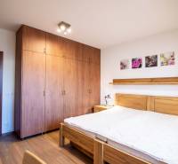 Nadštandardný 4-izbový rodinný dom s garážou a veľkým pozemkom - Spálňa s nábytkom z dreva a podlahou s dreveným dekorom v rodinnom dome.