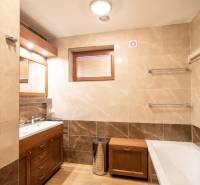 Nadštandardný 4-izbový rodinný dom s garážou a veľkým pozemkom - Kúpeľňa v rodinnom dome s vaňou, umývadlom, sprchovým kútom a podlahou s dreveným dekorom.
