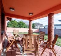 Nadštandardný 4-izbový rodinný dom s garážou a veľkým pozemkom - Terasa rodinného domu na Krajná ulici v Stupave s dreveným nábytkom a tehlovými stenami.