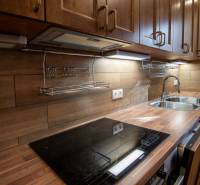 Nadštandardný 4-izbový rodinný dom s garážou a veľkým pozemkom - Kuchyňa v rodinnom dome s podlahou s dreveným dekorom a kuchynskou linkou z dreva.