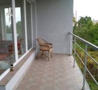 Zrekonštruovaný rodinný dom s peknou záhradou, Bystrička - Terasa rodinného domu v Bystričke s presklenými stenami a panoramatickým výhľadom.