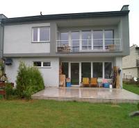 Zrekonštruovaný rodinný dom s peknou záhradou, Bystrička - Rodinný dom v Bystričke, terasa s posedením, veľké okná a upravený trávnik.