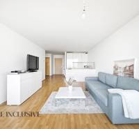 Na predaj luxusný 2-izb. byt s loggiou v Bratislave  - Obývačka s modrou pohovkou, bielym nábytkom a podlahou s dreveným dekorom v 2-izbovom byte.