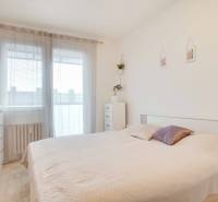 3-izbový byt s loggiou na sídlisku JUH, Nové Zámky – 61,37m2 - Spálňa v 3-izbovom byte so svetlou posteľou a komodou, dekorovaná rastlinou.