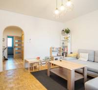 3-izbový byt s loggiou na sídlisku JUH, Nové Zámky – 61,37m2 - Obývacia izba v 3-izbovom byte s podlahou s dreveným dekorom a svetlým nábytkom.