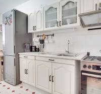 3-izbový byt s loggiou na sídlisku JUH, Nové Zámky – 61,37m2 - Kuchyňa v 3-izbovom byte s bielymi skrinkami, sporákom a veľkou chladničkou.