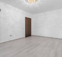 I Predaj 3- izbového bytu v Dúbravke - Izba s dverami a podlahou s dreveným dekorom v 3-izbovom byte.