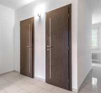 I Predaj 3- izbového bytu v Dúbravke - Interiér 3-izbového bytu s dlaždicovou podlahou a bielymi stenami, tmavé dvere.