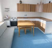 Bývajte vo svojom : dom a  pozemok 690 m², Veľké Ripňany 77.000,-EUR - Kuchyňa v rodinnom dome s modrým kobercom a drevenými skrinkami.