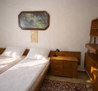 Bývajte vo svojom : dom a  pozemok 690 m², Veľké Ripňany 77.000,-EUR - Spálňa v rodinnom dome s dvomi posteľami, nočným stolíkom a obrazom na stene.