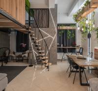 | Luxusný dvojúrovňový mezonet v Starom Meste - Podlaha s dreveným dekorom, schody, zelené rastliny a interiér 3-izbového bytu.