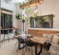 | Luxusný dvojúrovňový mezonet v Starom Meste - Jedáleň v 3-izbovom byte s bohatou zeleňou a vystlanými stoličkami, podlaha s dreveným dekorom.