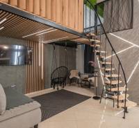 | Luxusný dvojúrovňový mezonet v Starom Meste - Interiér 3-izbového bytu s podlahou s dreveným dekorom a štýlovými schodmi.