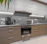 I Luxusný byt v historickom centre Bratislavy - Kuchyňa v 2-izbovom byte, moderné spotrebiče, šedá pracovná doska a úložné skrinky.