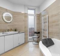 I Luxusný byt v historickom centre Bratislavy - Kúpeľňa v 2-izbovom byte s vaňou, umývadlom, zrkadlom a vyhrievaným rebríkovým radiátorom.