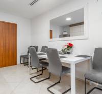 I Luxusný byt v historickom centre Bratislavy - Jedálenský stôl so sivými stoličkami a dekoráciami v interiéri 2-izbového bytu.