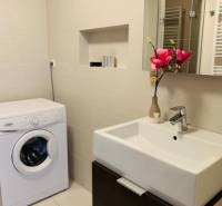 Na predaj 2-i byt s terasou pri Bratislavskom hrade - Kúpeľňa s práčkou, umývadlom a dekoráciou na ulici Palisády, 2-izbový byt.