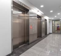I na predaj 2i byt v komplexe Tri Veže na Bajkalskej - Chodba s nerezovými výťahmi a lesklou kamennou podlahou v administratívnej budove.