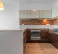 I na predaj 2i byt v komplexe Tri Veže na Bajkalskej - Kuchyňa v 2-izbovom byte s podlahou s dreveným dekorom a dreveným obkladom.