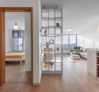 I na predaj 2i byt v komplexe Tri Veže na Bajkalskej - Interiér 2-izbového bytu s podlahou s dreveným dekorom, kuchyňou a obývačkou.