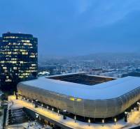 I na predaj 2i byt v komplexe Tri Veže na Bajkalskej - Zimný pohľad na osvetlený štadión a kancelársku budovu na Bajkalskej v Bratislave - Novom Meste.