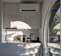 I Predaj Ecocapsule – autonómne ekologické bývanie - Kuchynská časť Zvláštnych nehnuteľností s bielou linkou, oblúkovým oknom a klimatizáciou.