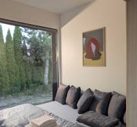 I Predaj Ecocapsule – autonómne ekologické bývanie - Zvláštne nehnuteľnosti s pohľadom na záhradu, posteľ s dekoračnými vankúšmi a obrazom.