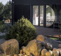 I Predaj Ecocapsule – autonómne ekologické bývanie - Skalka s kameňmi pred zvláštnou nehnuteľnosťou v Bratislave, obklopené zeleňou a stromami.