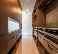 I Na predaj Luxusná vila „Tomma“ v Ubud, Bali - Šatník vo vile s jemne osvetlenými drevenými skriňami a šatníkovým systémom.