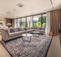 I Na predaj Luxusná vila „Tomma“ v Ubud, Bali - Svetlá obývacia izba vo vile s rohovou sedačkou, veľkým kobercom a gitarou.