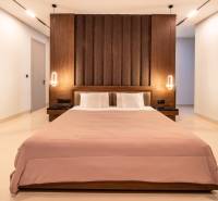 I Na predaj Luxusná vila „Tomma“ v Ubud, Bali - Štýlová spálňa vo vile s posteľou a osvetlením na stenách.