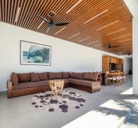 I Na predaj Luxusná vila „Tomma“ v Ubud, Bali - Obývacia izba vo vile s veľkou sedačkou, dreveným stropom a podlahou s dreveným dekorom.