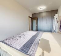 Na predaj nadštandardne zariadený 3 izb.byt, Trenčín, ul. Odevná - Spálňa s veľkou posteľou, vstavanou skriňou a podlahou s dreveným dekorom v 3-izbovom byte.