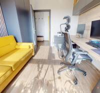 Na predaj nadštandardne zariadený 3 izb.byt, Trenčín, ul. Odevná - Pracovňa v 3-izbovom byte s podlahou s dreveným dekorom a žltou pohovkou.