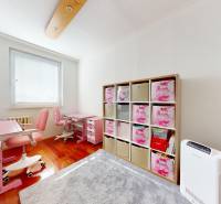 RADO I 4i byt, 90m2 I ul. Opatovská I Trenčín - Detská izba so stolíkmi, stoličkami, regálmi a podlahou s dreveným dekorom v 4-izbovom byte.