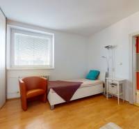 RADO I 4i byt, 90m2 I ul. Opatovská I Trenčín - Spálňa v 4-izbovom byte s jednolôžkom, kreslom a podlahou s dreveným dekorom.