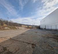 Predaj, výrobný a veľkoobchodný areál v okrese Veľký Krtíš - Výrobné priestory vo Veľkom Krtíši s asfaltovou plochou a oplotením, priemyselná oblasť.