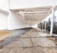 Predaj, výrobný a veľkoobchodný areál v okrese Veľký Krtíš - Exteriér výrobných priestorov vo Veľkom Krtíši s betónovou podlahou a bielymi stenami.