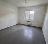 Predaj, výrobný a veľkoobchodný areál v okrese Veľký Krtíš - Izba s bielymi stenami, sivou podlahou a malým oknom vo výrobných priestoroch.