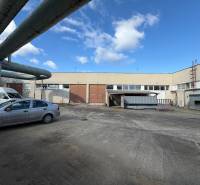 Predám skladovú halu v Nových Zámkoch - Sklady a haly v Nových Zámkoch na ulici Nové Zámky s priemyselným komplexom a autami.