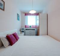 Predaj 4-izbového bytu, Vyšehradská, Vyšehradská, Petržalka - Spálňa so svetlým nábytkom a dekoratívnymi vankúšmi v 4-izbovom byte.