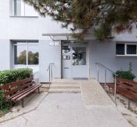 Predaj 4-izbového bytu, Vyšehradská, Vyšehradská, Petržalka - Vchod do budovy na Vyšehradskej ulici v Bratislave - Petržalke s lavičkami a zeleňou.