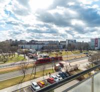 Komfortný 1,5-izbový byt s balkónom v Ružinove na predaj - Výhľad na rušnú ulicu v Bratislave - Ružinov, Súmračná, s električkou a parkom.