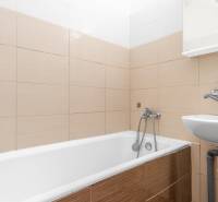 Komfortný 1,5-izbový byt s balkónom v Ružinove na predaj - Kúpeľňa s vaňou a umývadlom v 1-izbovom byte, béžová dlažba.