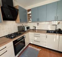 Vkusný 3 izb. byt po kompl. rekonštrukcii - Jilemnického ulica -72m2 - Kuchyňa v 3-izbovom byte s kachličkovaným obkladom a podlahou s dreveným dekorom.