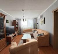 Vkusný 3 izb. byt po kompl. rekonštrukcii - Jilemnického ulica -72m2 - Obývacia izba s pohodlnou sedačkou, podlahou s dreveným dekorom a príjemným osvetlením v 3-izbovom byte.